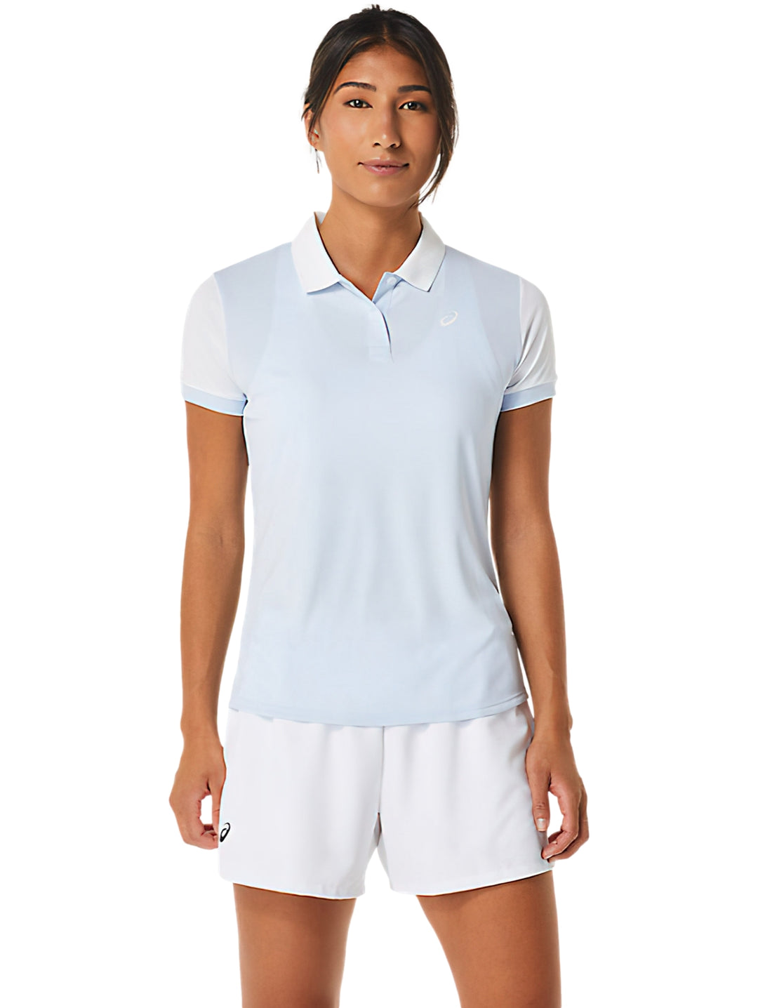 Mujer vistiendo polo deportivo ASICS color celeste y blanco con shorts blancos.