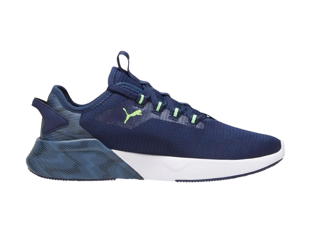 Tenis deportivos PUMA color azul marino con suela blanca y detalles en verde neón.