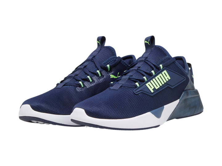 Tenis deportivos PUMA color azul marino con suela blanca y detalles en verde neón.
