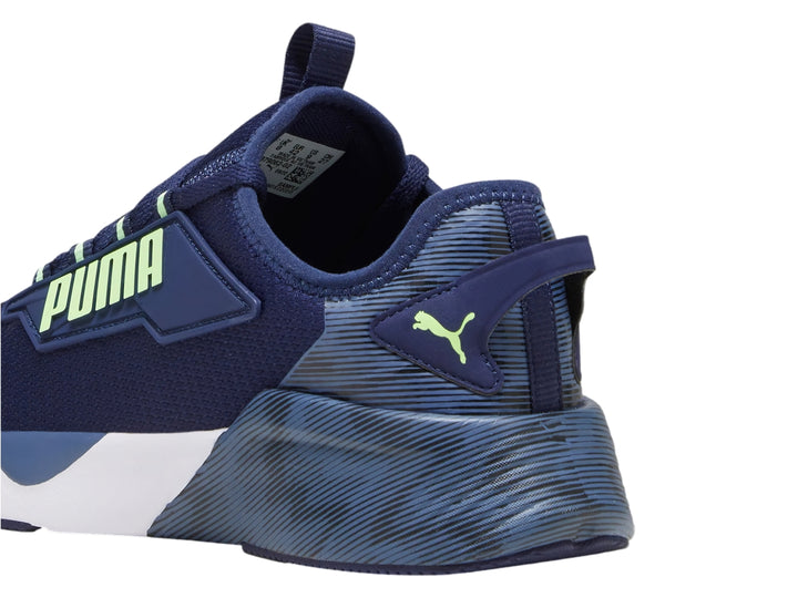 Tenis deportivos PUMA color azul marino con suela blanca y detalles en verde neón.