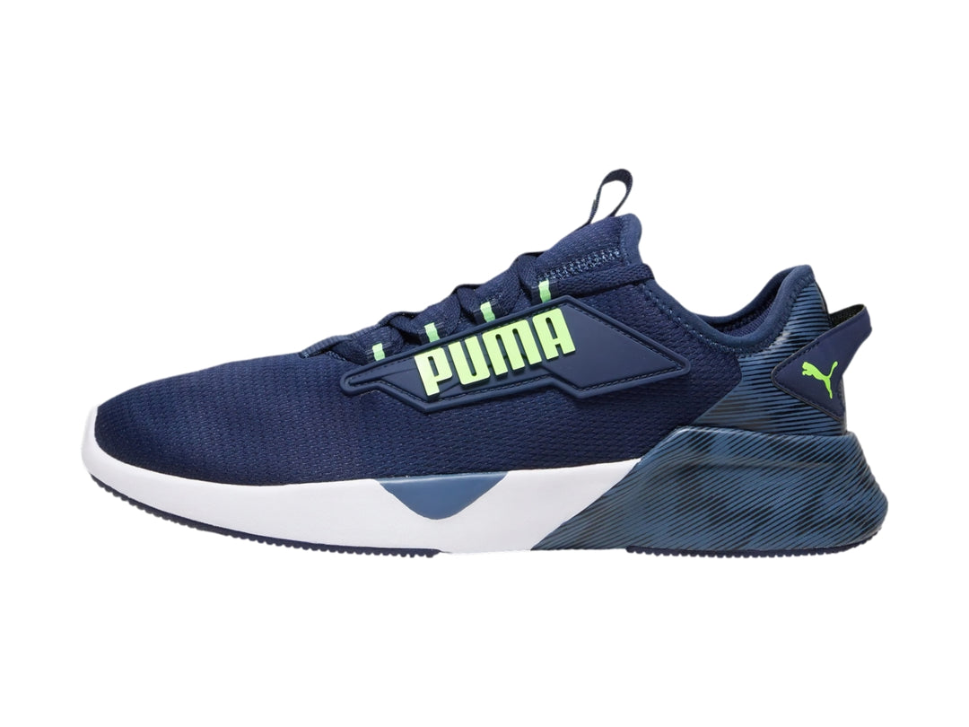 Tenis deportivos PUMA color azul marino con suela blanca y detalles en verde neón.