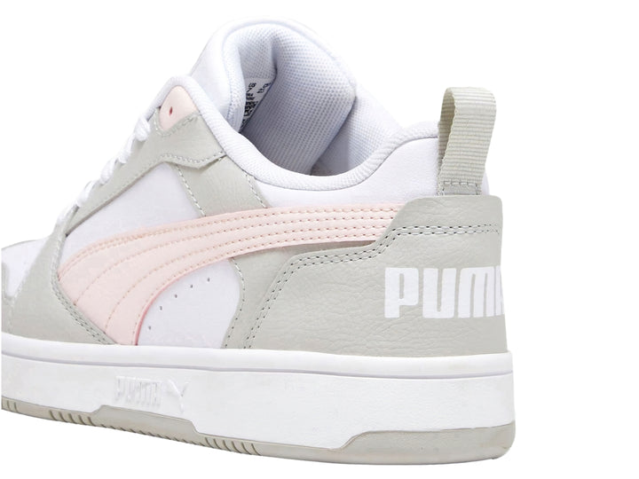 Tenis PUMA Rebound V6 Low color blanco con detalles en gris y una franja rosa pastel.