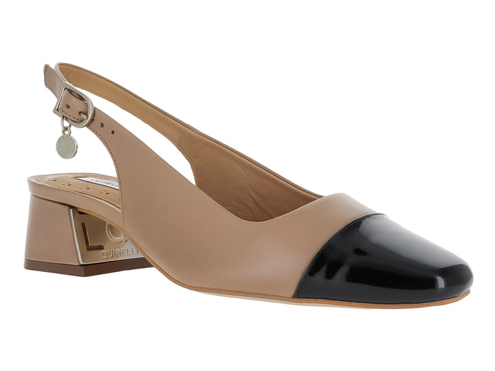 Zapato de tacón cuadrado color nude con punta negra y correa ajustable.