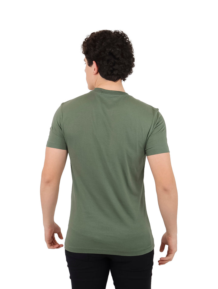 Hombre vistiendo camiseta Calvin Klein Jeans de color verde con logotipo blanco en el pecho y corte slim.