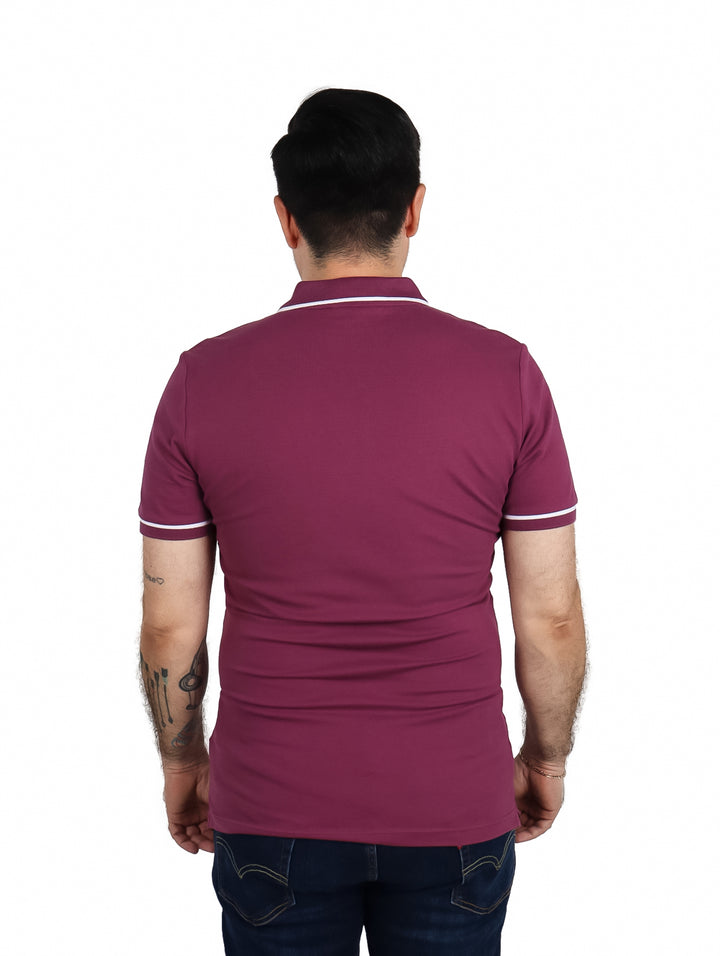 Hombre vistiendo una playera polo color morado de Calvin Klein con detalles blancos en cuello y mangas.