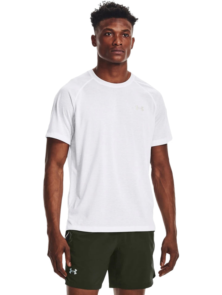 Hombre vistiendo una playera deportiva Under Armour de color blanco con cuello redondo y manga corta.