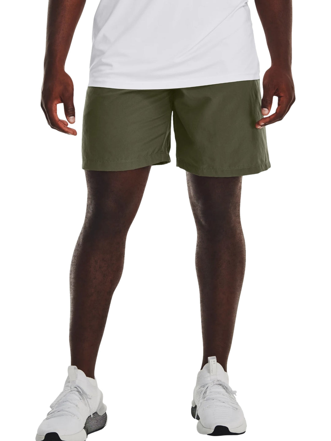 Hombre vistiendo shorts deportivos de color verde oliva de la marca Under Armour.