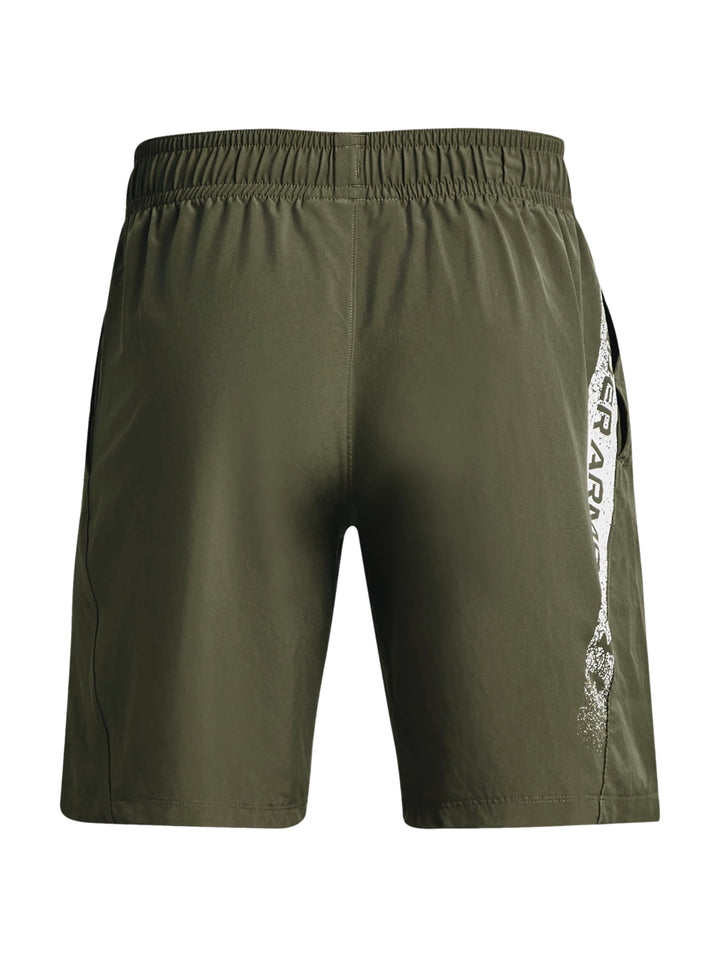 Hombre vistiendo shorts deportivos de color verde oliva de la marca Under Armour.