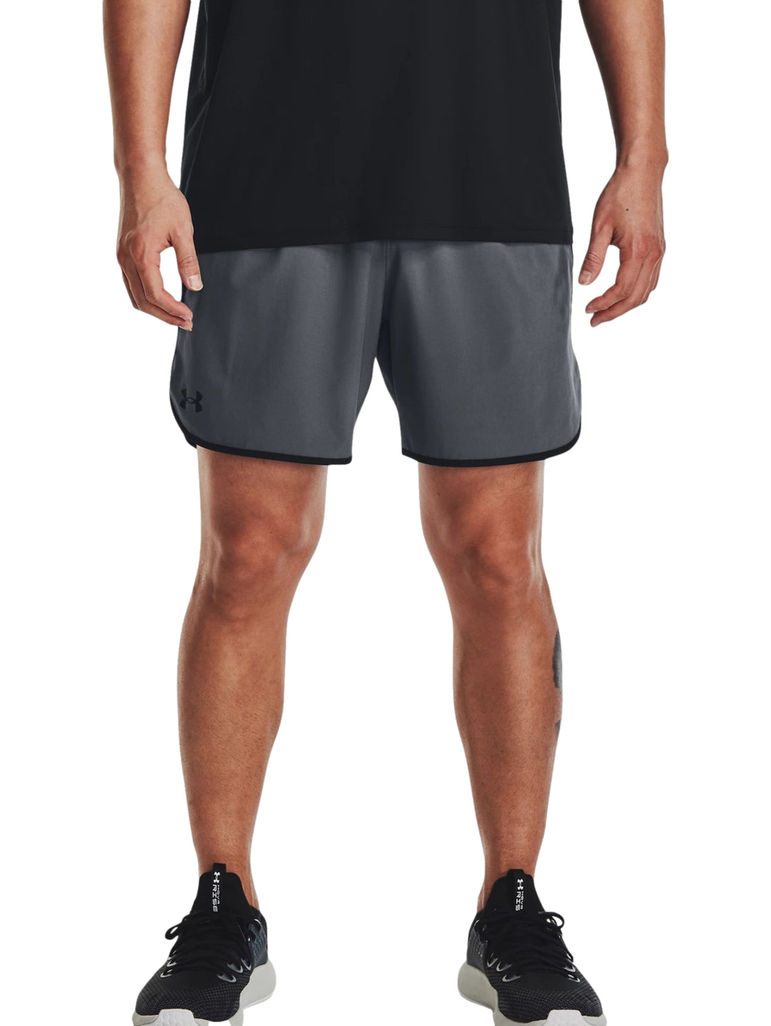Hombre vistiendo shorts deportivos Under Armour color gris oscuro con detalles negros en los bordes.