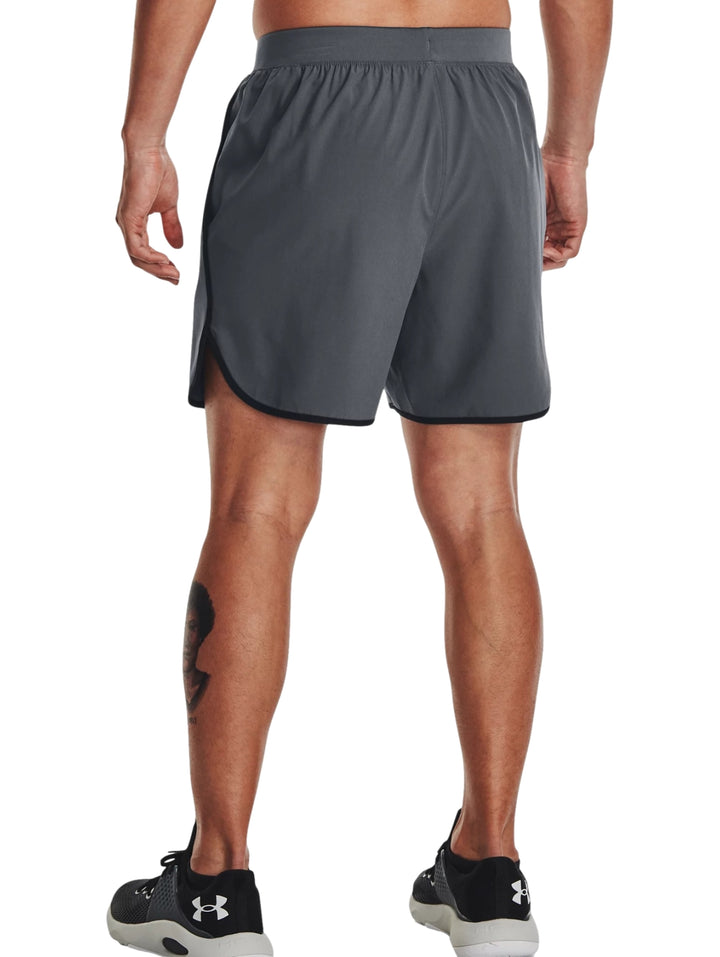 Hombre vistiendo shorts deportivos Under Armour color gris oscuro con detalles negros en los bordes.