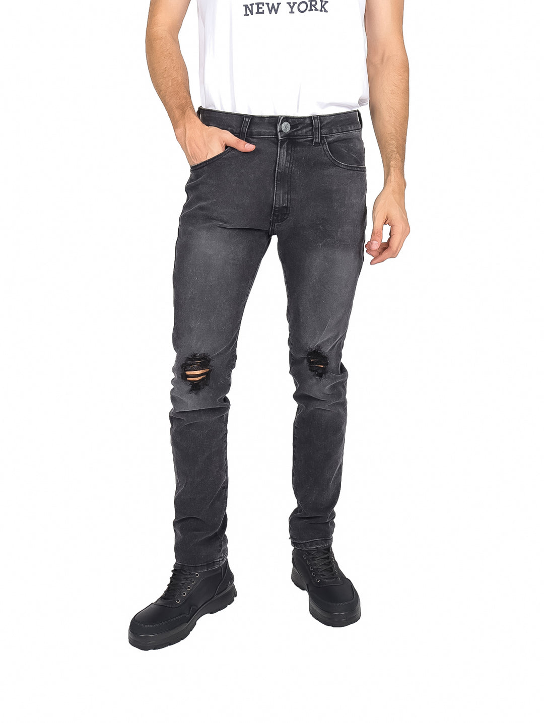 Hombre usando pantalón negro de mezclilla con roturas en las rodillas.