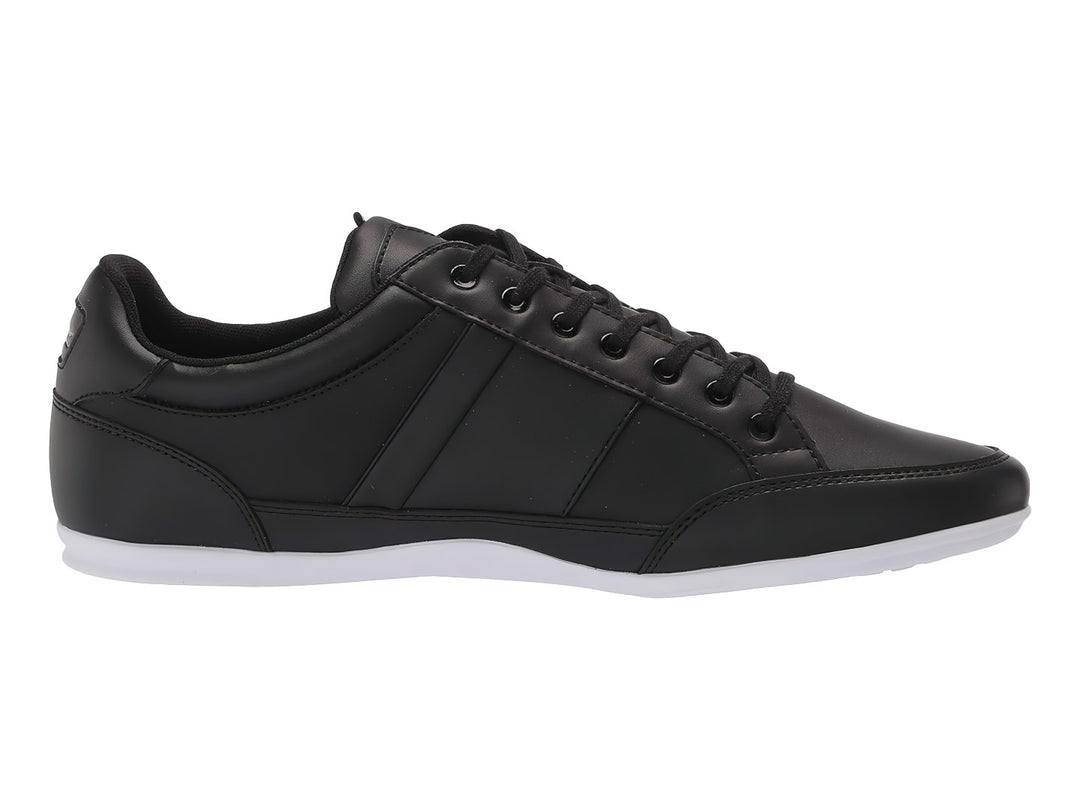 Tenis deportivos Lacoste en color negro con suela blanca y agujetas negras.