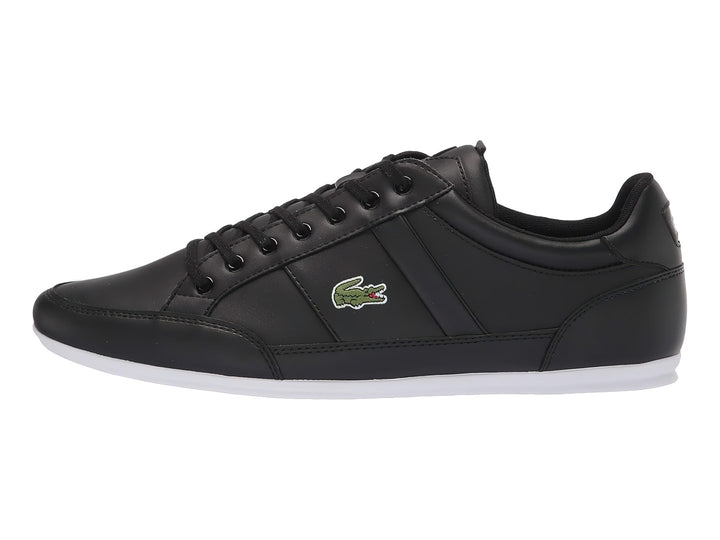 Tenis deportivos Lacoste en color negro con suela blanca y agujetas negras.