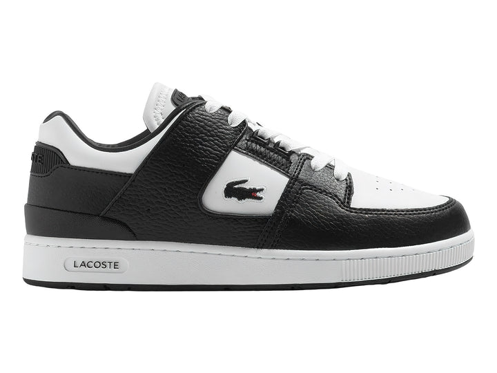 Tenis deportivos Lacoste de cuero en colores blanco y negro con suela blanca y logo del cocodrilo.
