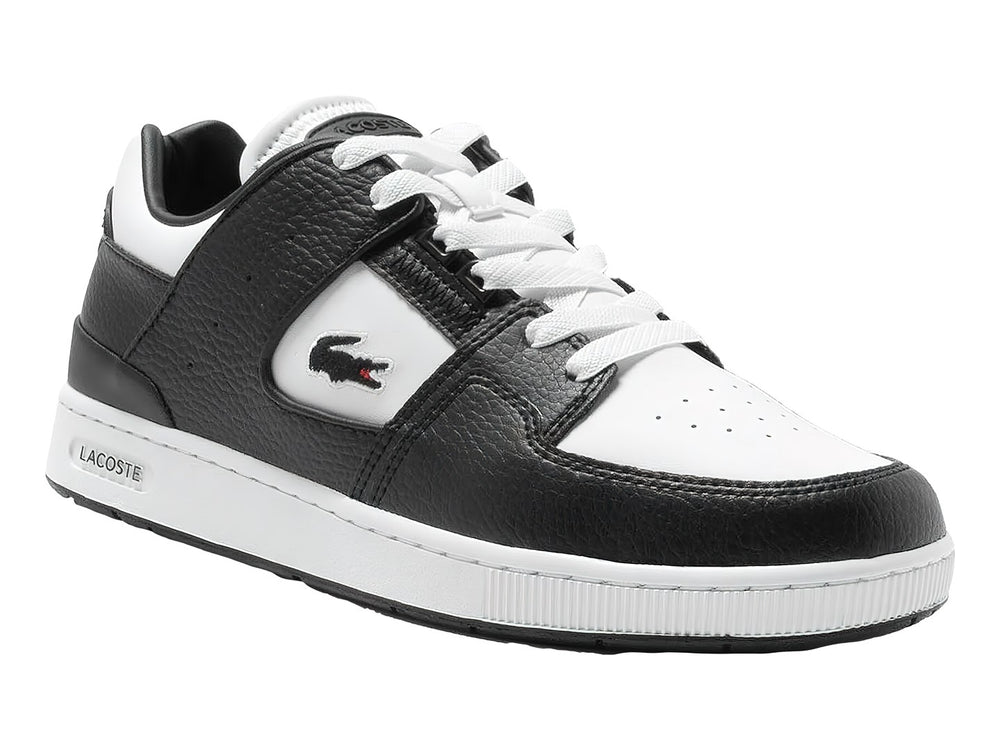 Tenis deportivos Lacoste de cuero en colores blanco y negro con suela blanca y logo del cocodrilo.