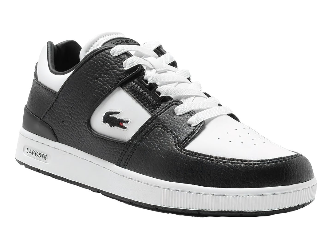 Tenis deportivos Lacoste de cuero en colores blanco y negro con suela blanca y logo del cocodrilo.