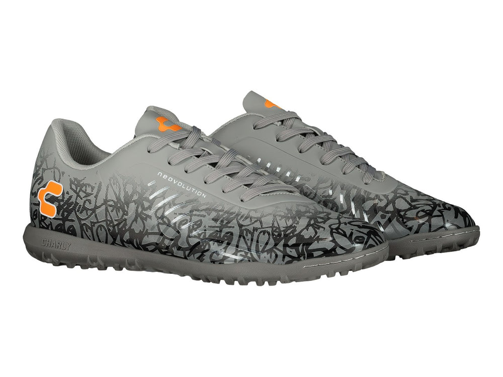 Zapato de fútbol Charly color gris con patrones negros y detalles en naranja, suela para turf.