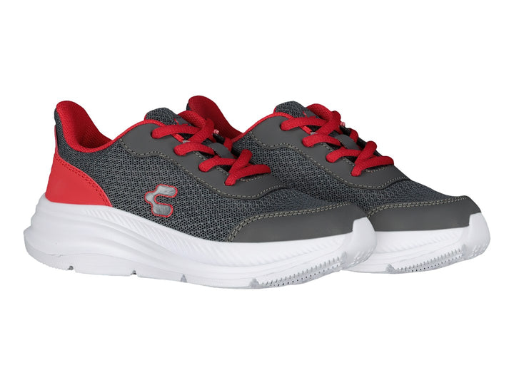 Tenis deportivos Charly color gris con detalles rojos y suela blanca.