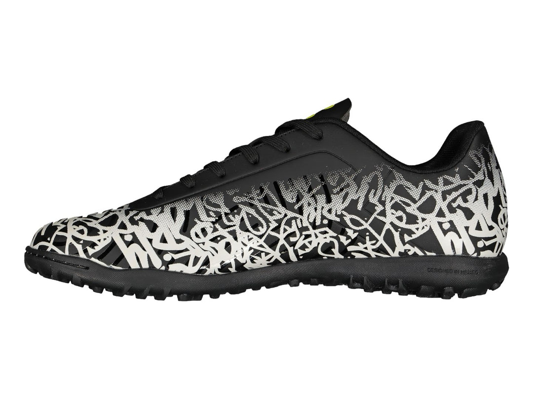 Tenis de fútbol Charly en color negro y blanco con diseño de graffiti y detalles amarillos.