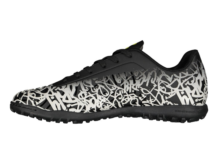 Tenis de fútbol Charly en color negro y blanco con diseño de graffiti y detalles amarillos.
