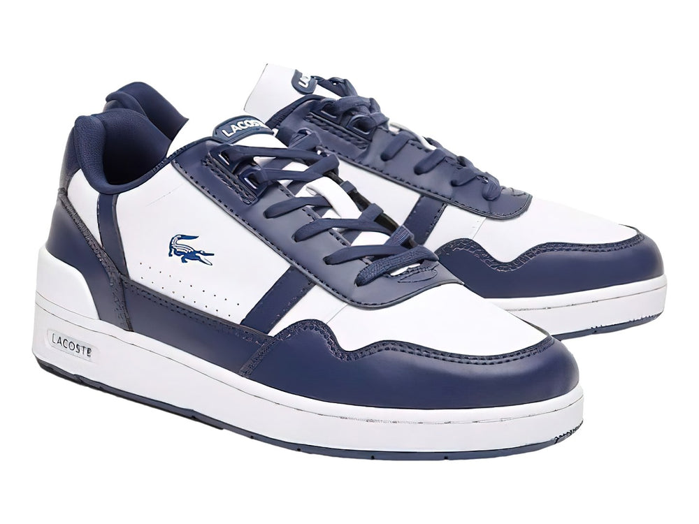 Tenis deportivos Lacoste para niño en colores blanco y azul marino con suela blanca y logotipo del cocodrilo.