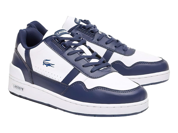 Tenis deportivos Lacoste para niño en colores blanco y azul marino con suela blanca y logotipo del cocodrilo.