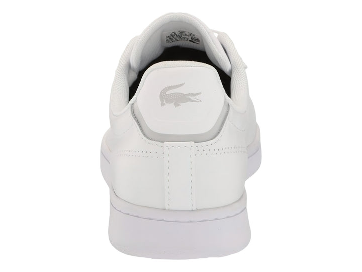 Tenis blancos Lacoste Carnaby Evo de cuero sintético con suela plana y cordones blancos.