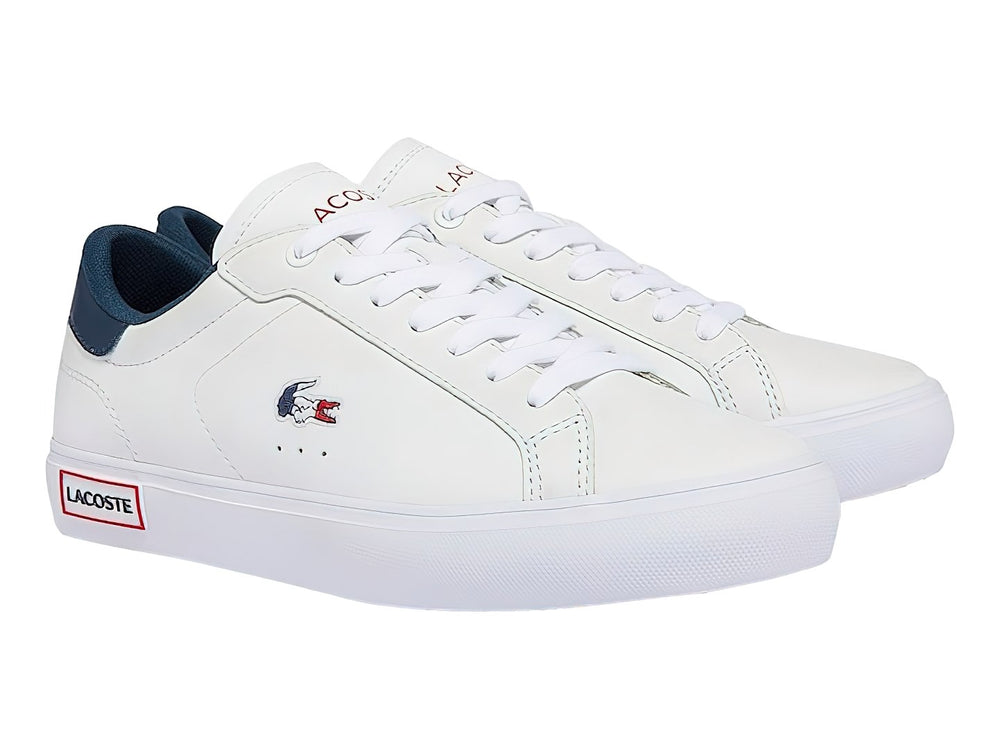 Tenis blancos Lacoste con detalles en azul marino y rojo, diseño casual de corte bajo.