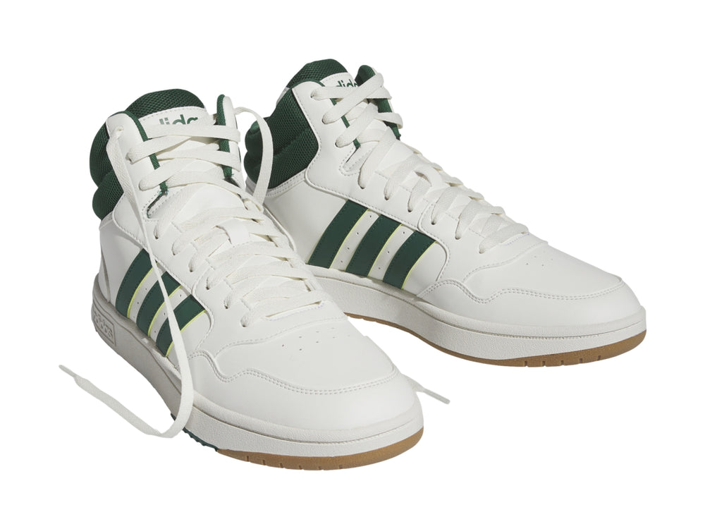 Tenis Adidas Hoops 3.0 Mid color blanco con detalles en verde y suela color goma.