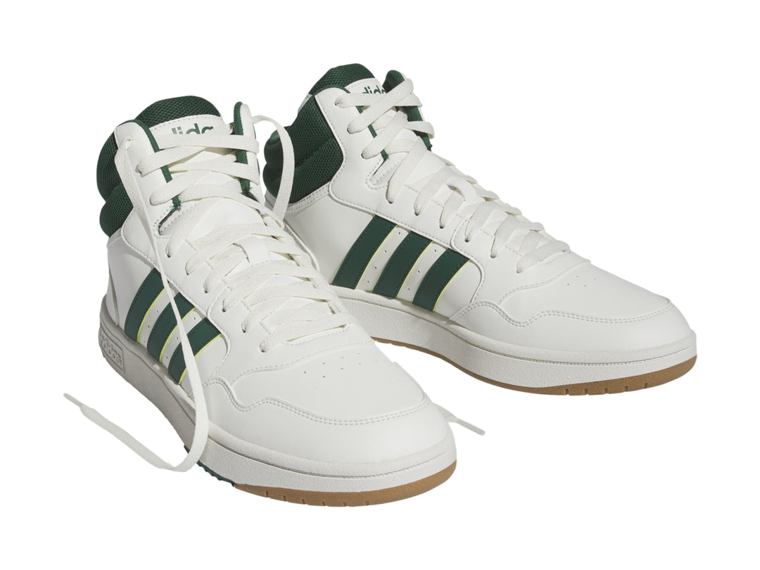 Tenis Adidas Hoops 3.0 Mid color blanco con detalles en verde y suela color goma.