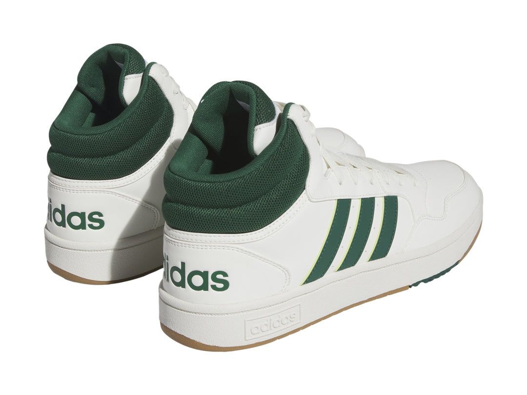 Tenis Adidas Hoops 3.0 Mid color blanco con detalles en verde y suela color goma.