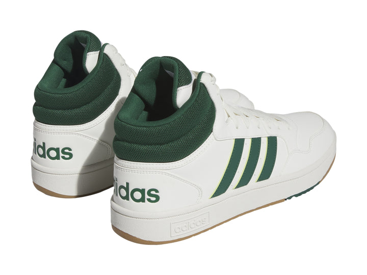 Tenis Adidas Hoops 3.0 Mid color blanco con detalles en verde y suela color goma.