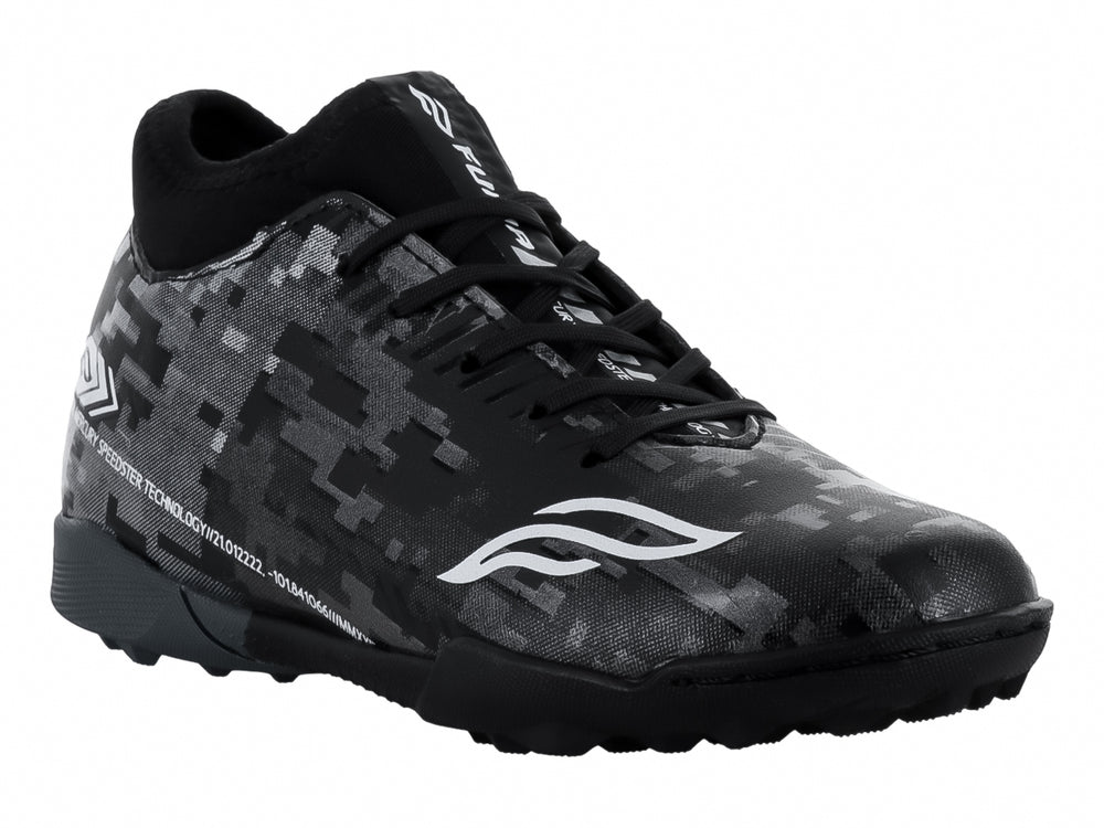 Calzado de fútbol Furia para niños en color negro y plata con patrón pixelado y suela para césped sintético.