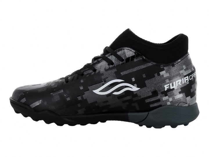 Calzado de fútbol Furia para niños en color negro y plata con patrón pixelado y suela para césped sintético.