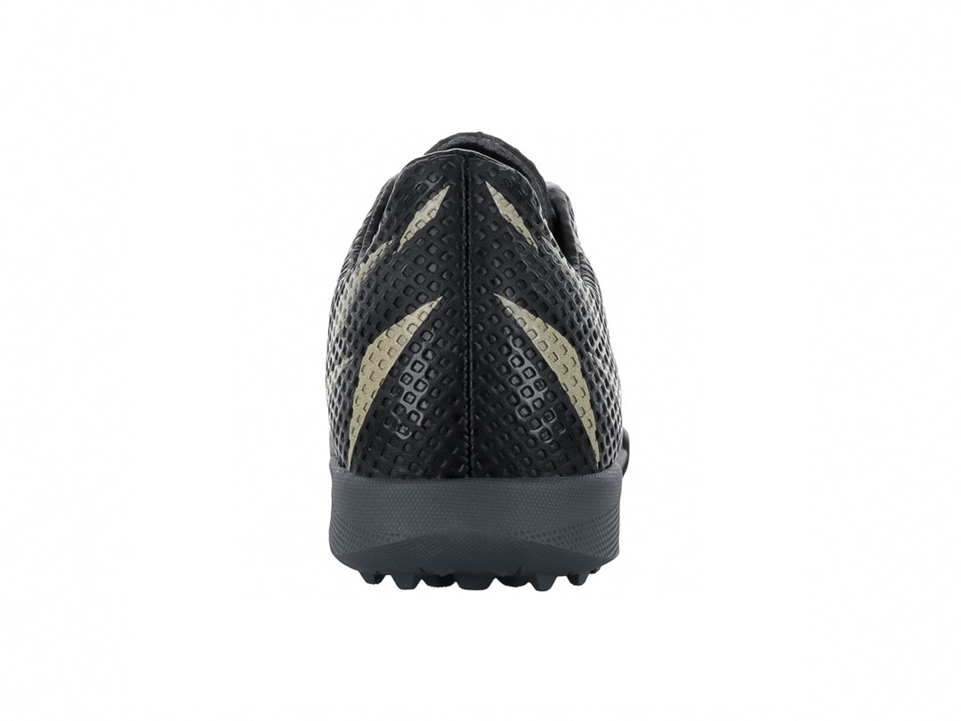 Zapato de fútbol Furia Ultra en color negro con detalles en oro y suela para césped sintético.
