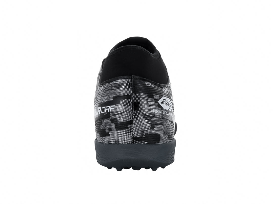 Calzado de fútbol Furia en color negro y plata con diseño de camuflaje digital y suela para pasto sintético.