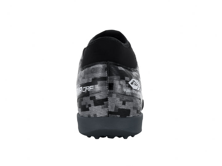 Calzado de fútbol Furia en color negro y plata con diseño de camuflaje digital y suela para pasto sintético.