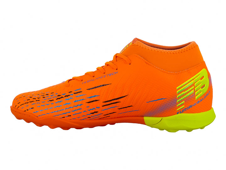 Zapato de fútbol Furia color naranja con suela verde lima y detalles decorativos laterales.