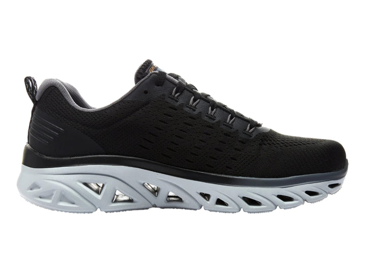 Tenis deportivos Skechers color negro con suela gris clara esculpida y parte superior de malla.