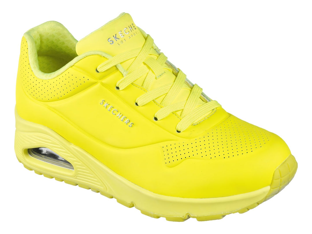 Tenis deportivos Skechers color amarillo neón con suela amortiguada y detalles perforados.