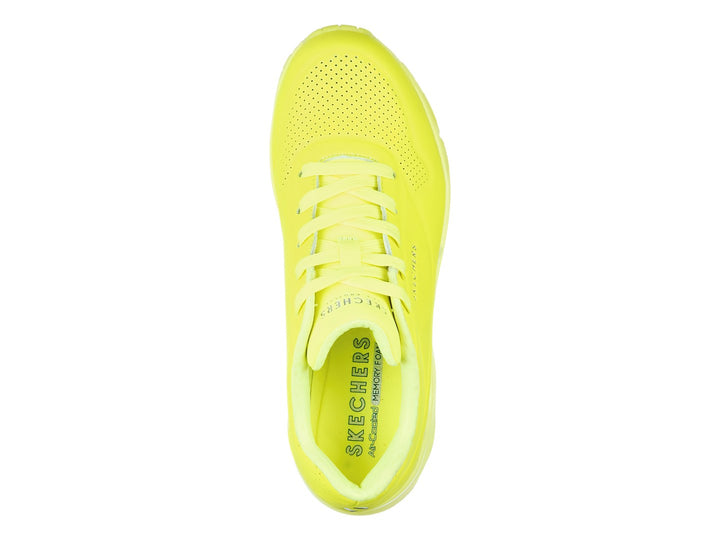 Tenis deportivos Skechers color amarillo neón con suela amortiguada y detalles perforados.