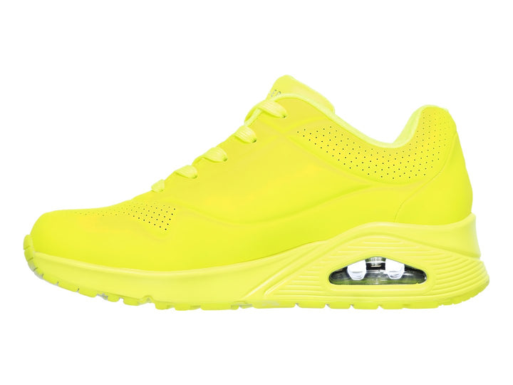 Tenis deportivos Skechers color amarillo neón con suela amortiguada y detalles perforados.