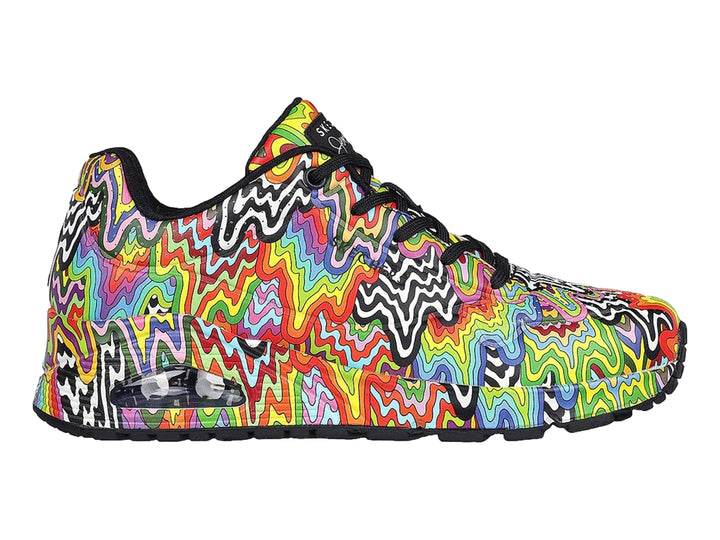 Tenis Skechers con diseño de ondas multicolores y suela negra.