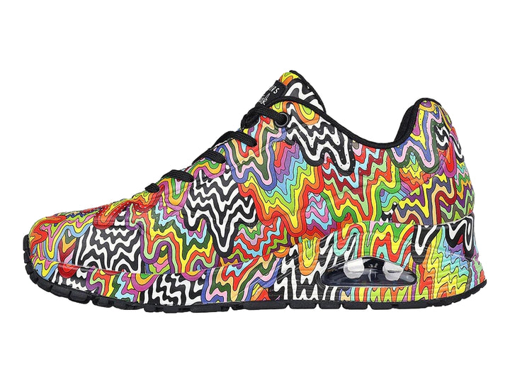 Tenis Skechers con diseño de ondas multicolores y suela negra.