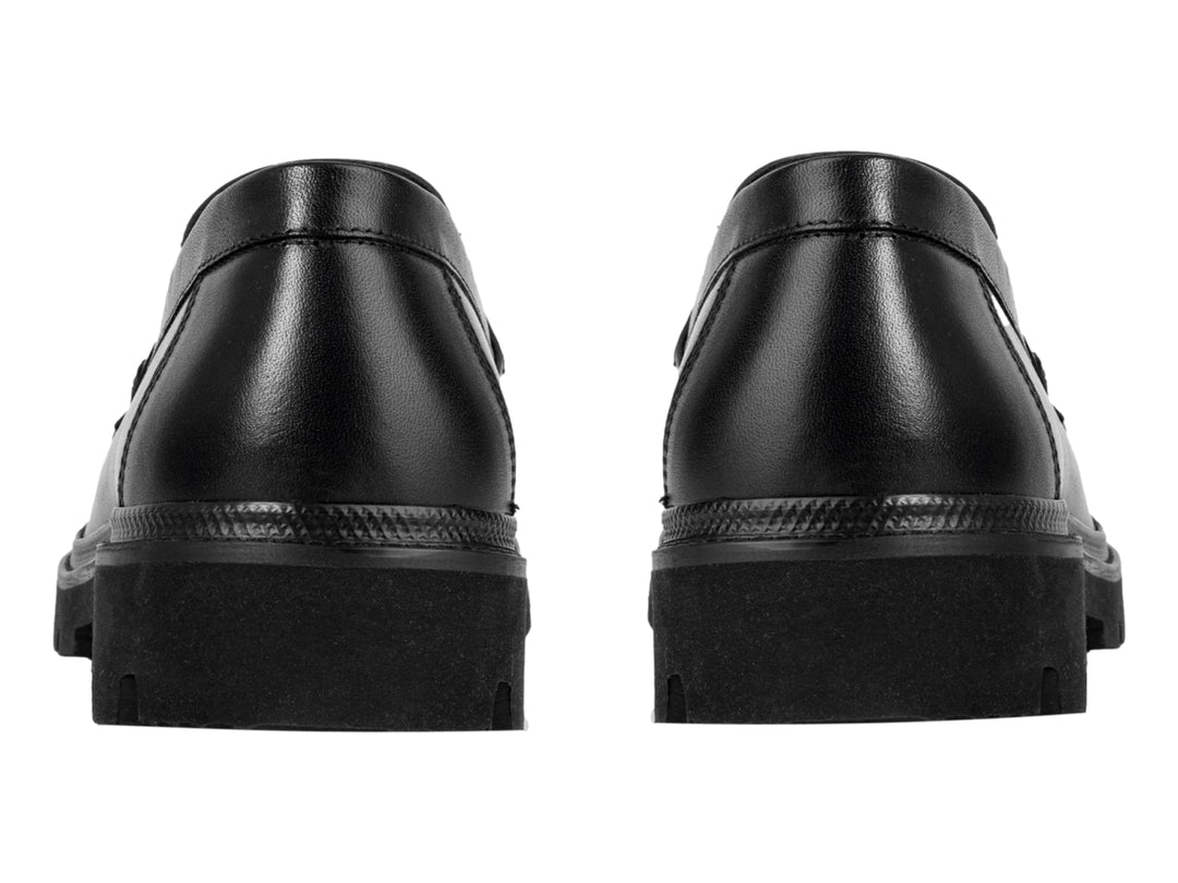Zapato mocasín negro con suela track gruesa y detalle metálico en la parte superior.