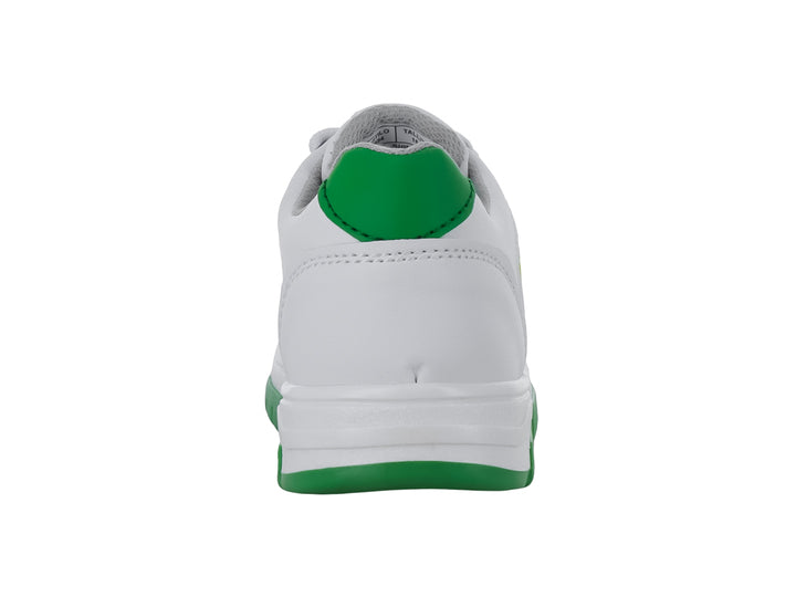 Tenis blancos para niño con franjas amarillas, azules y verdes en el lateral y suela verde.