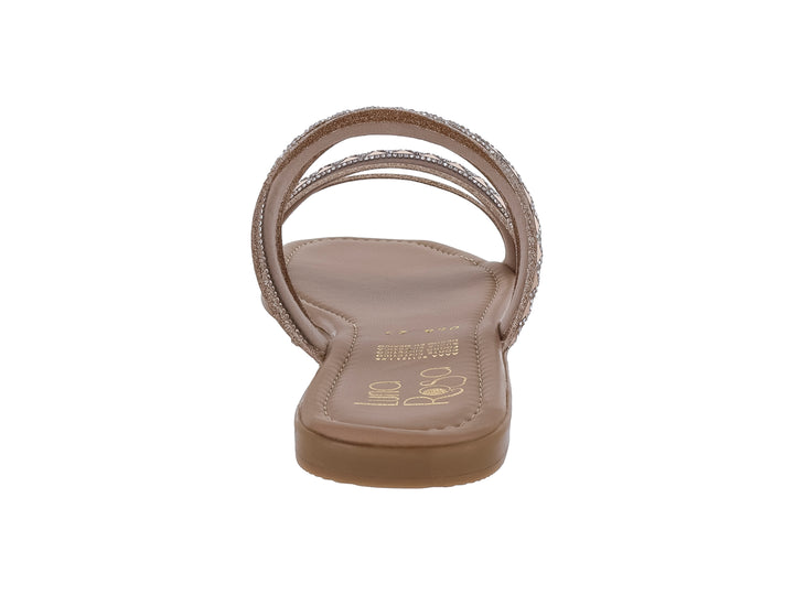 Sandalia plana color oro rosado con tiras decoradas con patrón de rombos y detalles brillantes.