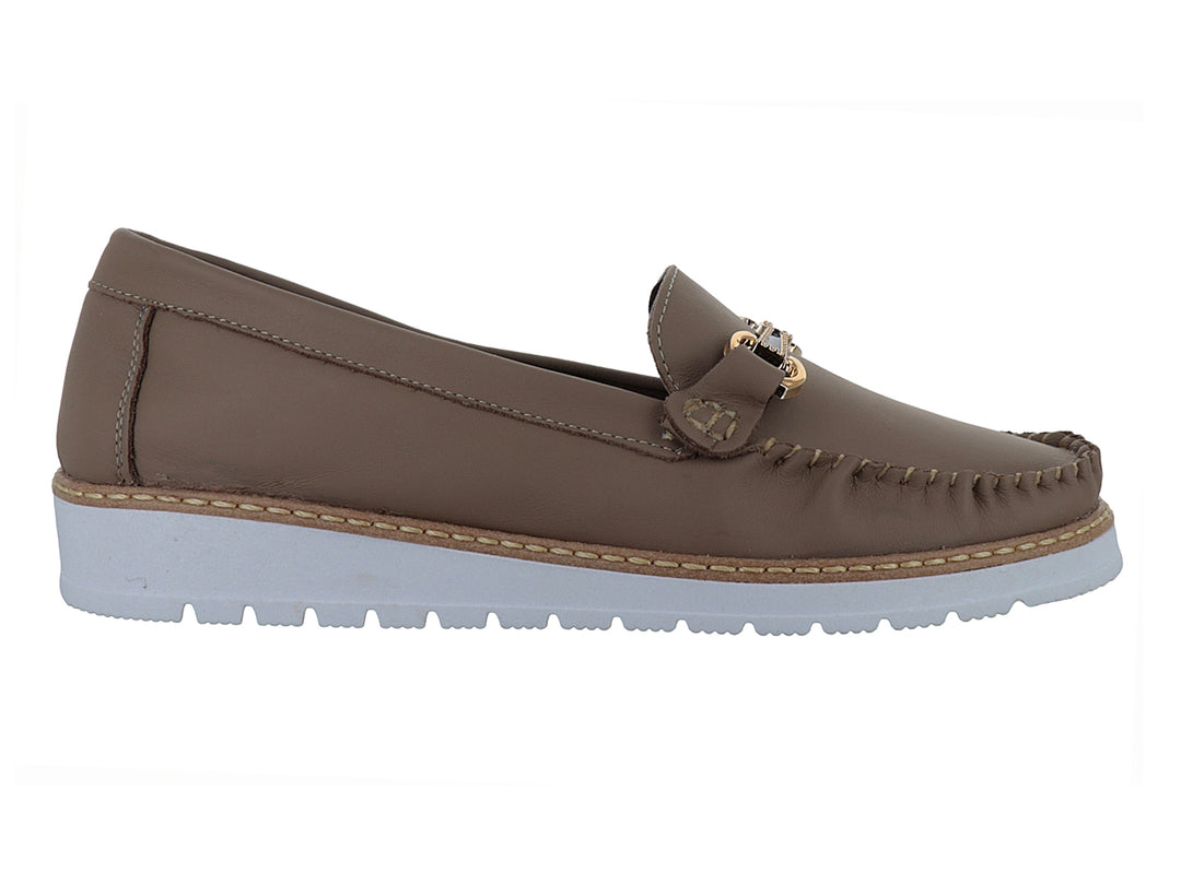 Zapato mocasín color marrón cajeta con suela blanca gruesa y detalle de hebilla dorada.