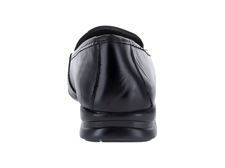 Zapato plano tipo mocasín de piel color negro con detalles perforados en la parte superior.