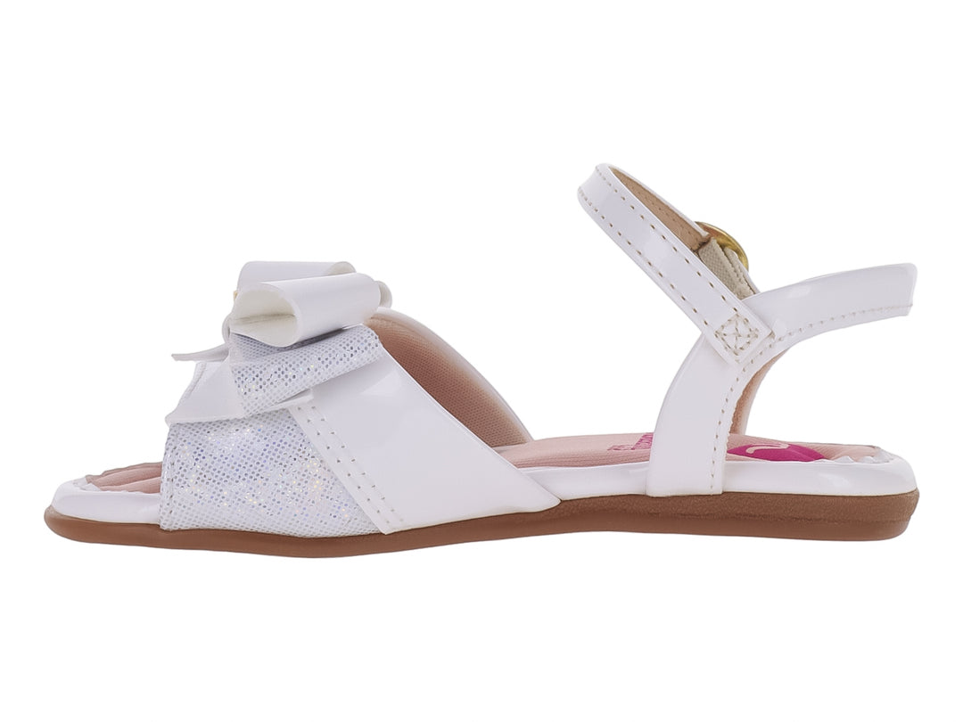 Sandalia blanca para niña con acabado brillante, detalle de moño frontal y correa con hebilla dorada.